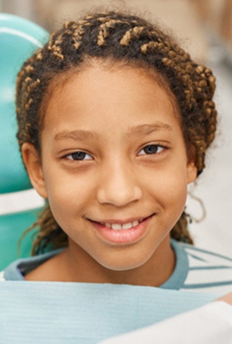 child smiling while visiting dentist 