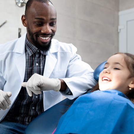 young girl smiling while visiting dentist 