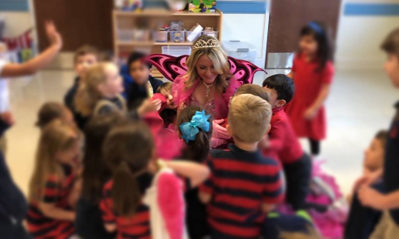 Dental team member dressed as tooth fairy talking to kids