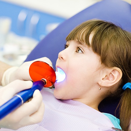 Child receiving dental bonding treatment