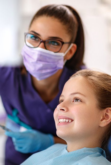 A young girl in a dental chair with a female dentist