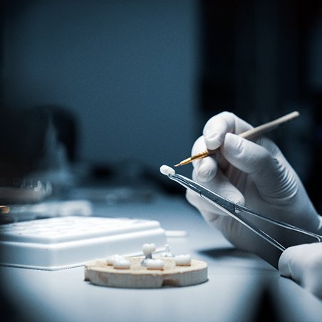 A lab worker making dental crowns