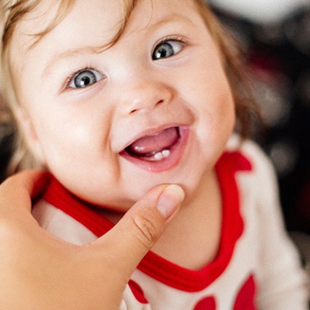 A baby smiling while their bottom teeth are exposed in Wylie