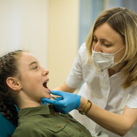 Dentist examining child's smile during emergency dentistry visit