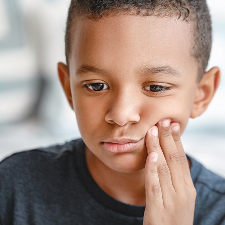 Young boy in pain before tooth extraction