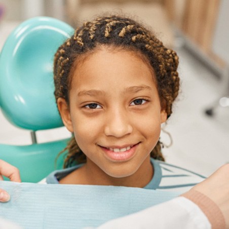 young girl smiling while visiting dentist 