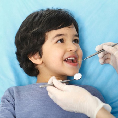 young boy smiling while visiting dentist