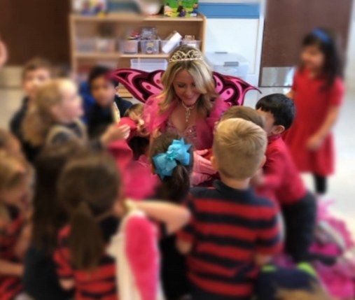 Dental team member dressed as tooth fairy talking to kids