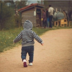 Child walking down a dirt path