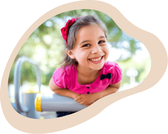 Little girl smiling at a playground outdoors