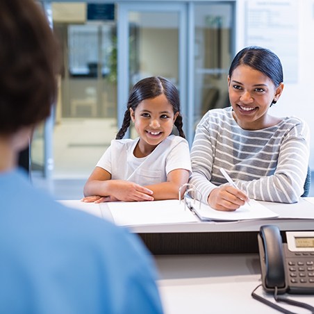 Mother and child checking in at dental office