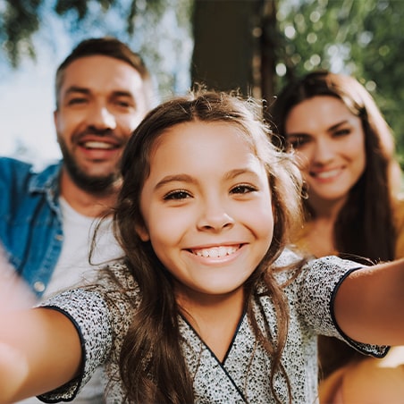 Daughter and parents take a selfie outdoors