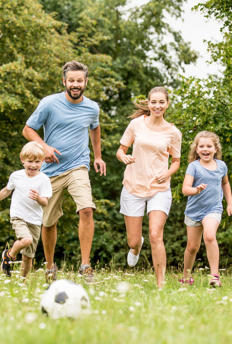 Family of four smiling together outdoors