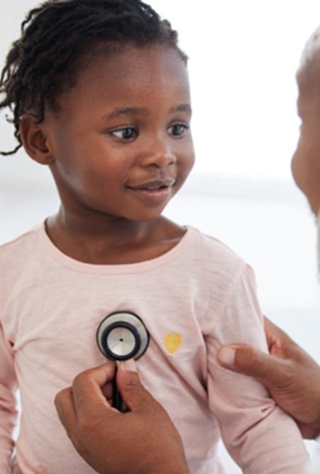 pediatric dentist listening to a child’s heartbeat