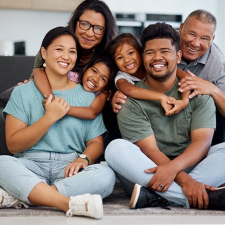 a happy family smiling and sitting on a couch together 