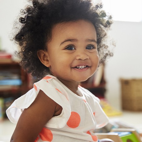 Little girl smiling after early childhood caries detection visit