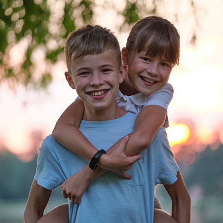 Smiling siblings, both candidates for dental sealant treatment