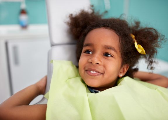 Little girl smiling after children's dental checkup and teeth cleaning