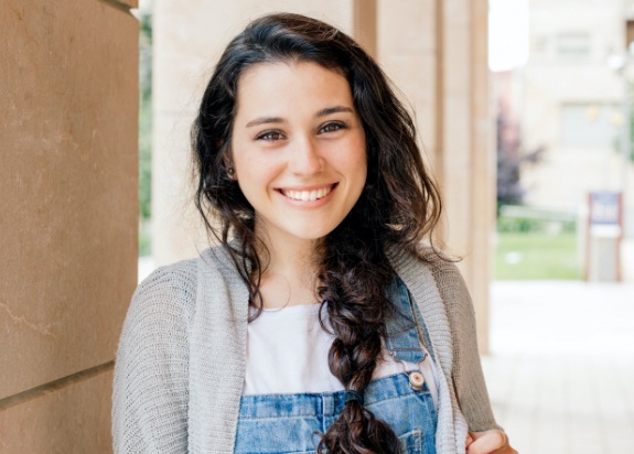 Young woman smiling after cosmetic dentistry for children