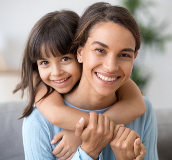 child hugging their parent from behind