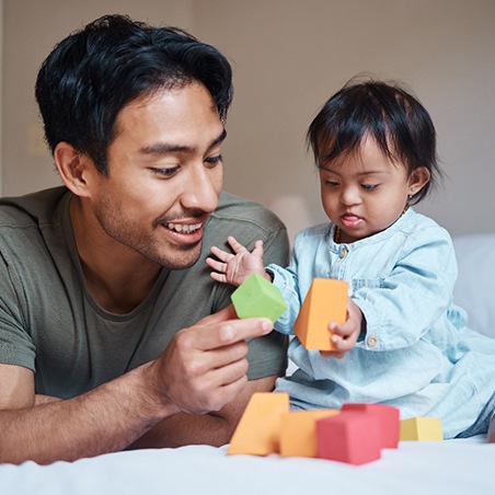 a parent playing with their infant 