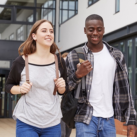 Two teens with healthy smiles after dentistry for young adults