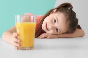 a child with a glass of fruit juice