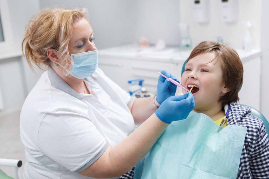 A dental assistant applying SDF to a child’s tooth